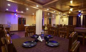 uma sala de jantar com uma mesa com uma garrafa de água em Hotel Kalinga Grand - Top Rated Most Awarded Property In Manali em Manali mais 17 fotografias