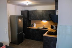 a small kitchen with a stainless steel refrigerator at Green Mountain in Sallanches