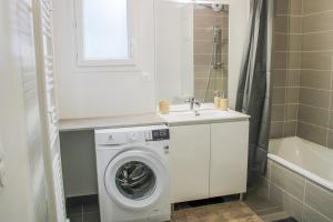 a bathroom with a washing machine and a sink at Green Mountain in Sallanches