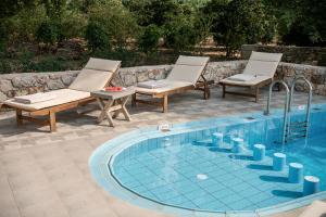 a swimming pool with two lounge chairs and a swimming pool at Villa Nature, Heated Pool in Kalyves