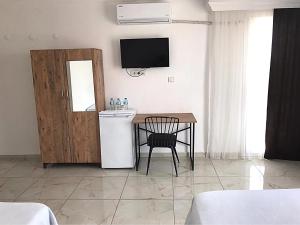 a kitchen with a table and a television in a room at Ayvaz Otel in Torbalı