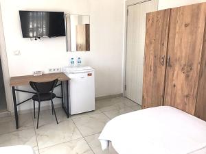 a small kitchen with a table and a small refrigerator at Ayvaz Otel in Torbalı