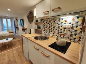 a kitchen with a sink and a tea kettle on a counter at Studio vieille ville tout équipé sans ascenseur in Menton