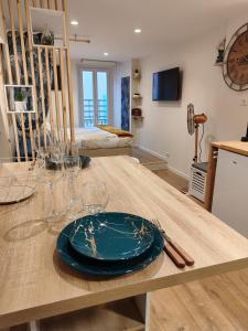 a dining room table with a blue plate on it at Studio vieille ville tout équipé sans ascenseur in Menton