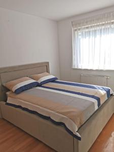 a large bed in a room with a window at Apartman MERI in Strmec Samoborski