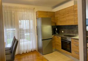 cocina con nevera de acero inoxidable junto a una ventana en Apartman MERI, en Strmec Samoborski