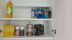 a cupboard with a coffee maker and other items at Elegant CBD Apartment in Christchurch +8 photos