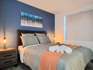 a bedroom with a bed with two towels on it at Elegant CBD Apartment in Christchurch