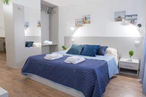 a bedroom with a blue bed with towels on it at Teatro Romano Centro Storico Wi-FI Centralissima in Terracina