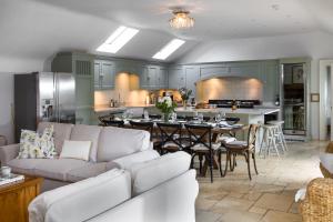 una cucina e un soggiorno con divano e tavolo di Windrush a Colesbourne