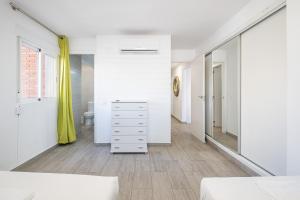 ベニドルムにあるAgua Azul 4-A Apartment Levante-Rincon de Loixの白い壁のベッドルーム(大きな鏡付)