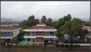 Casa blanca con techo rojo y árboles en Mizzle Exotica Lonavala, en Lonavala