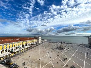 a city square with a cloudy sky and the water at Room in the Heart of Historic Lisbon on Rua Augusta in Lisbon