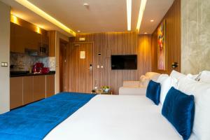 a bedroom with a large white bed with blue pillows at First Suites Hôtel in Rabat
