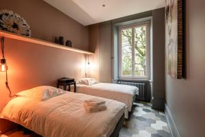 2 camas en una habitación con ventana en Espace Formes d'Art en Belfort