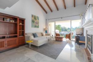 a living room with a couch and a tv at Golf Duplex con piscina en La Quinta Golf Marbella in Málaga