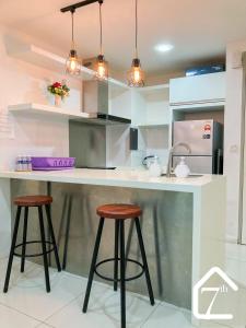 een keuken met een aanrecht en 2 krukken bij 7th Avenue Stay (Sutera Avenue) in Kota Kinabalu