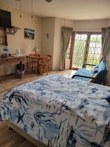 sypialnia z łóżkiem, stołem i krzesłami w obiekcie Fig Tree Manor Self Catering w mieście Blythedale