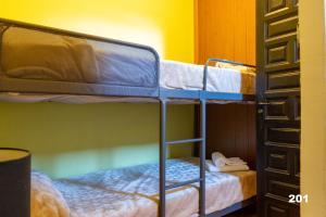 ウーニャにあるHotel Uña Serranía Encantadaの二段ベッド2組が備わるドミトリールームで、もう1台のベッドが備わります。