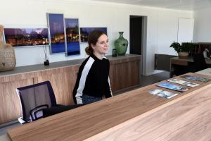 a woman sitting at a table in an office at Camping Bella Vista in Calvi