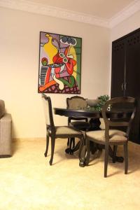 a dining room with a table and chairs and a painting at Sublime studio - Gauthier in Casablanca