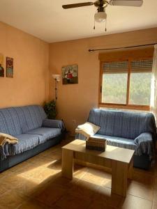 a living room with two blue couches and a coffee table at Casa Rural E Puente del Segura in Elche de la Sierra