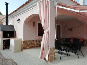 a patio with a table and chairs and a fireplace at Casa Rural E Puente del Segura in Elche de la Sierra