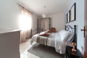 a bedroom with a bed with white walls and a window at Alle porte del Montefeltro - Maison Torriana in Torriana
