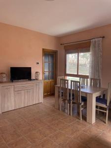 a dining room with a table and a television at Casa Rural E Puente del Segura in Elche de la Sierra +40 photos