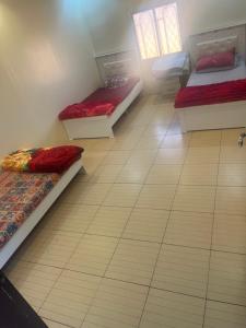 a room with three beds sitting on a tiled floor at استراحات ومخيم يمك دروبي in Madain Saleh