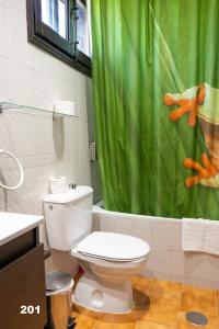 a bathroom with a toilet and a green shower curtain at Hotel Uña Serranía Encantada in Uña