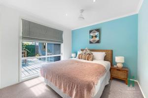 a bedroom with a bed and a large window at Private Jetty Kayaks Pets allow WoyWoy Bay in Woy Woy