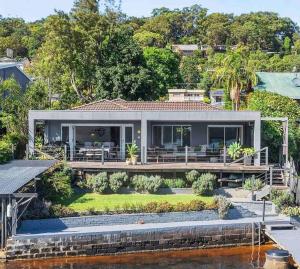 a house on the water with a large dock at Private Jetty Kayaks Pets allow WoyWoy Bay in Woy Woy