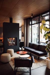 sala de estar con sofá y chimenea en Golden Tulip Keyser Breda Centre, en Breda