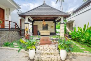 a home with a porch with a stone wall at Kulta Villa Bali in Munggu