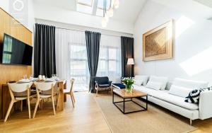 a living room with a white couch and a table at Wonder Home - Apartamenty z widokiem na góry, blisko stoków narciarskich i szlaków turystycznych in Karpacz