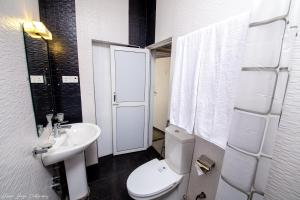 a bathroom with a white toilet and a sink at Asian House in Colombo
