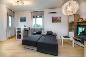 a living room with a bed and a television at City break apartment in Čakovec