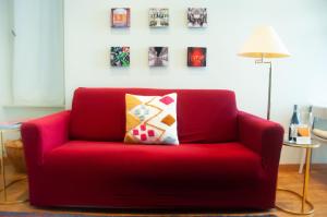 a red couch with a pillow in a living room at Suite Sommeiller Comfort in centro in Turin
