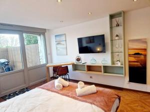 a bedroom with a bed with a television and a desk at L'Instant Détente in Barneville-Carteret