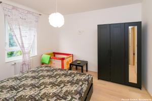 a bedroom with a bed and a black cabinet at City break apartment in Čakovec