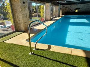 uma piscina com um corrimão de metal junto à relva em La Causserie, 2 Chambres d'Hôtes, 2 à 4 invités, pour vous seuls em Gramat