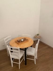 einen Holztisch mit weißen Stühlen und einem Tisch sowie einem Tisch und einem Chairsktop in der Unterkunft La Petite Vernoelle in Prémilhat