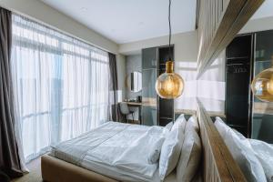 a bedroom with a bed and a large window at Hotel Sky Station in Tbilisi City