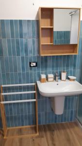 Baño de azulejos azules con lavabo y espejo en CASA MASCIA en Cencenighe