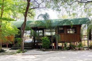 um edifício com um telhado verde com árvores em Mukuku Rest Camp em Shimweghe