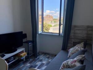 salon z kanapą i dużym oknem w obiekcie Casa Della Rovere w Rzymie