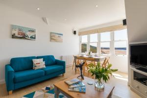 Una sala de estar con un sofá azul y una mesa. en 5 Hartland House, en Woolacombe