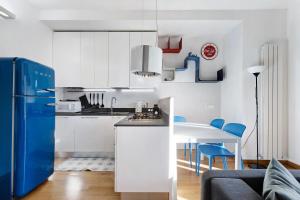 una cucina con armadi bianchi e frigorifero blu di La casetta di Ale a La Spezia