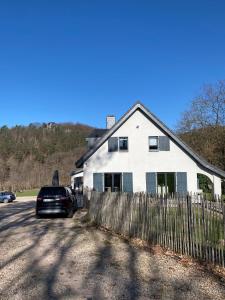 a car parked in front of a white house at Studio & Appartement au Lac in Sart-lez-Spa